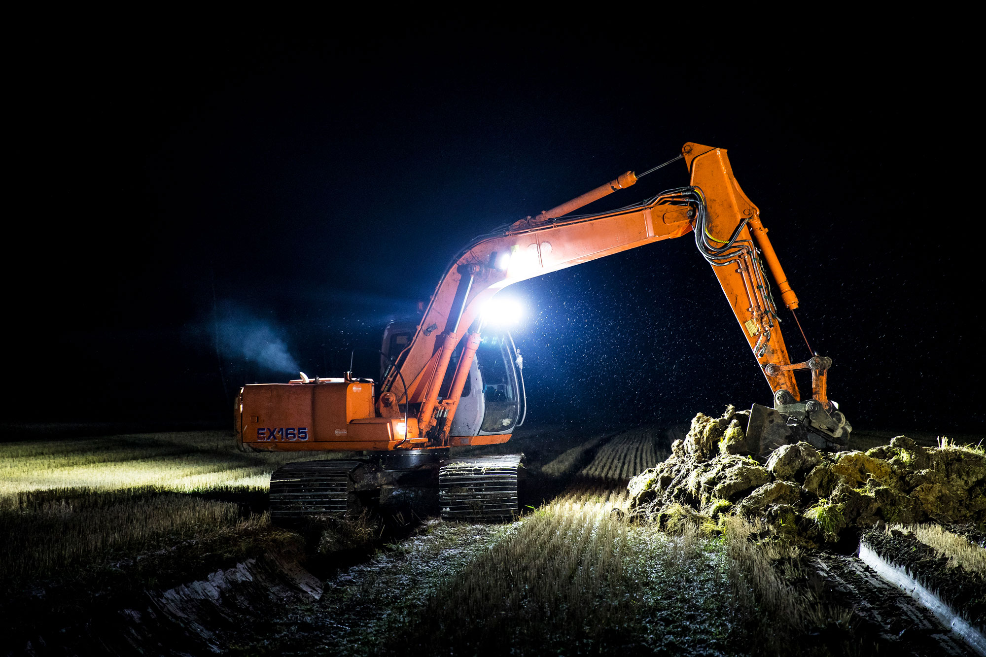 Orange excavator digging with Nordic Lights LED Lights